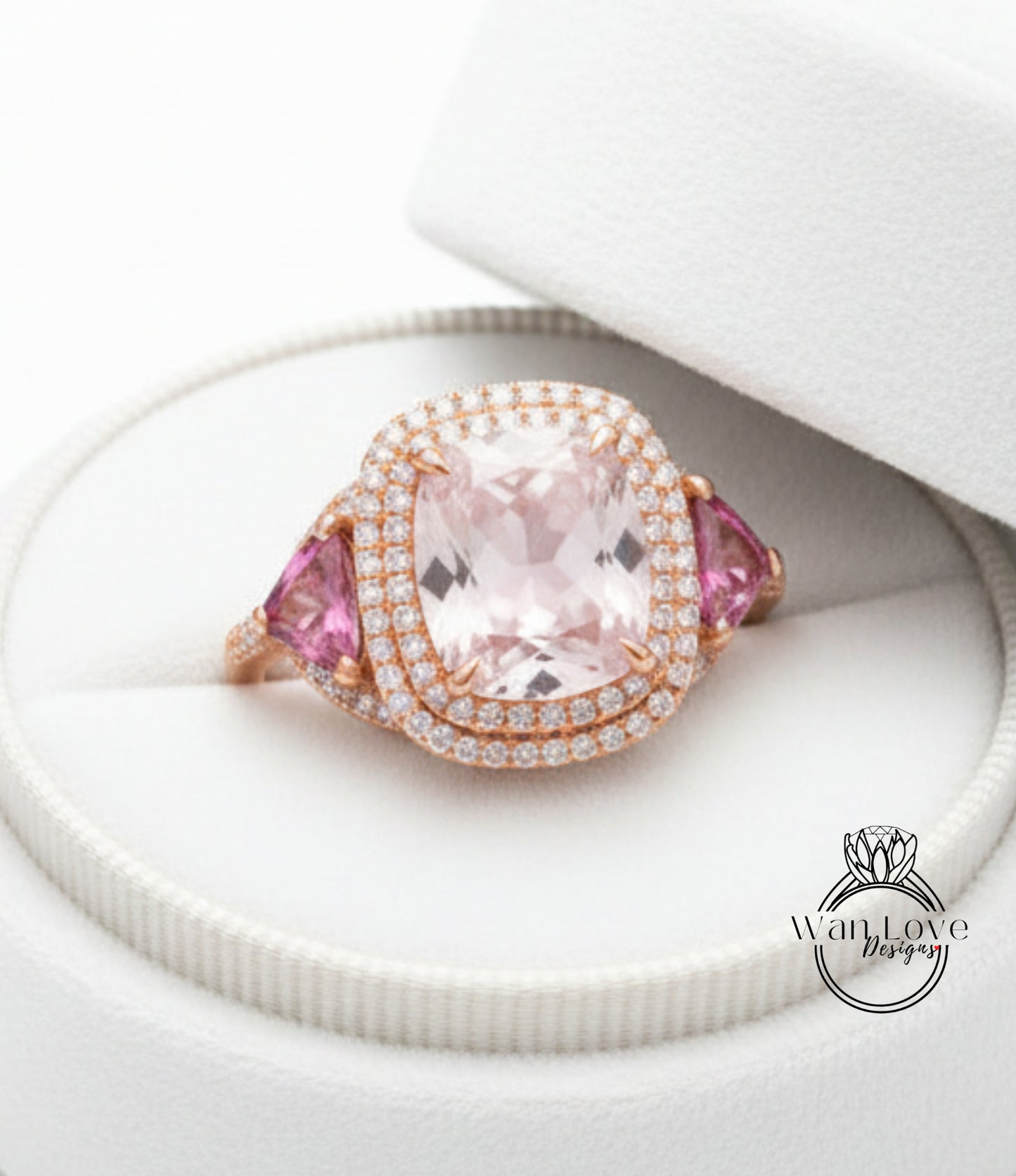 A large, pink gemstone ring with a halo of diamonds set in a white box.