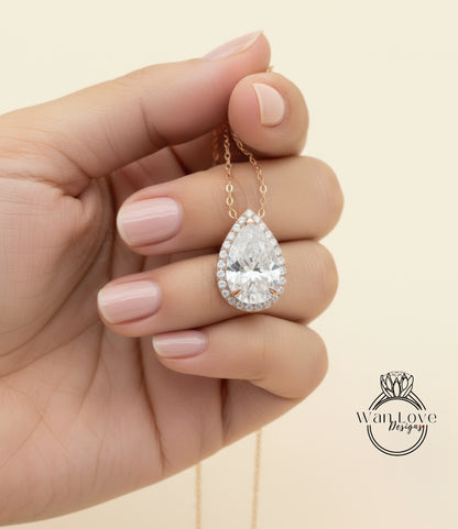 A hand holding a delicate necklace with a large, sparkling diamond pendant.