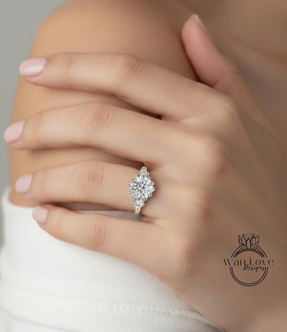 A close-up of a person's hand wearing a diamond engagement ring on the ring finger.