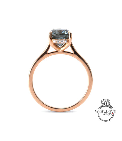 A rose gold engagement ring with a large blue gemstone set in the center.
