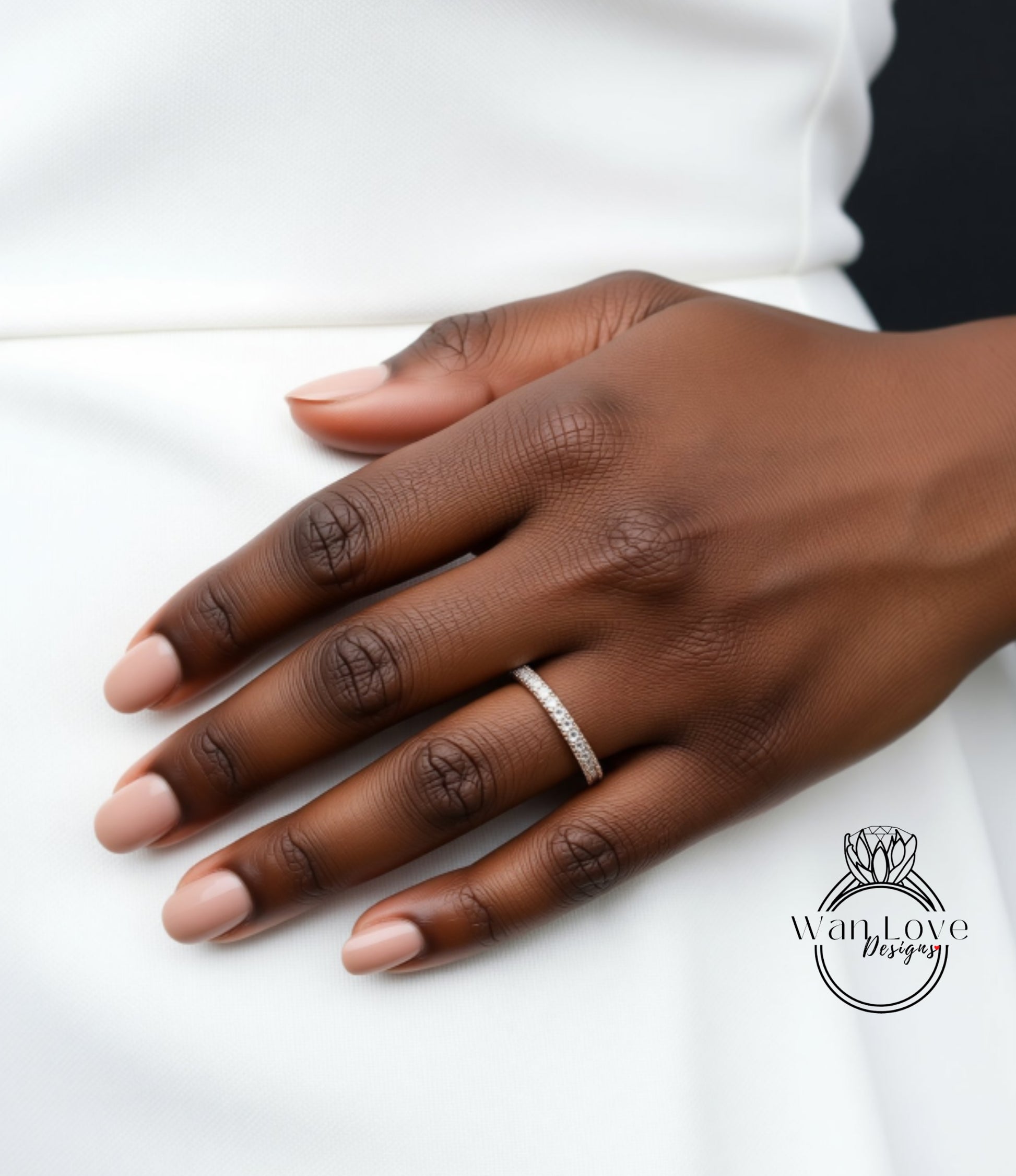 A close-up of a hand wearing a ring on the ring finger.