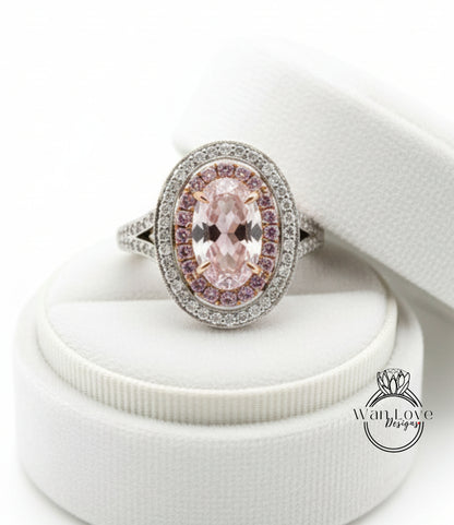A diamond ring with a large oval-shaped pink gemstone surrounded by smaller diamonds, placed on a white jewelry box.