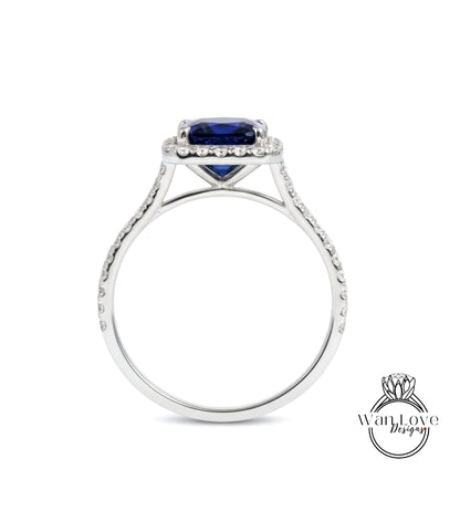 A silver ring with a large blue gemstone, likely a sapphire, set in a halo of smaller diamonds.