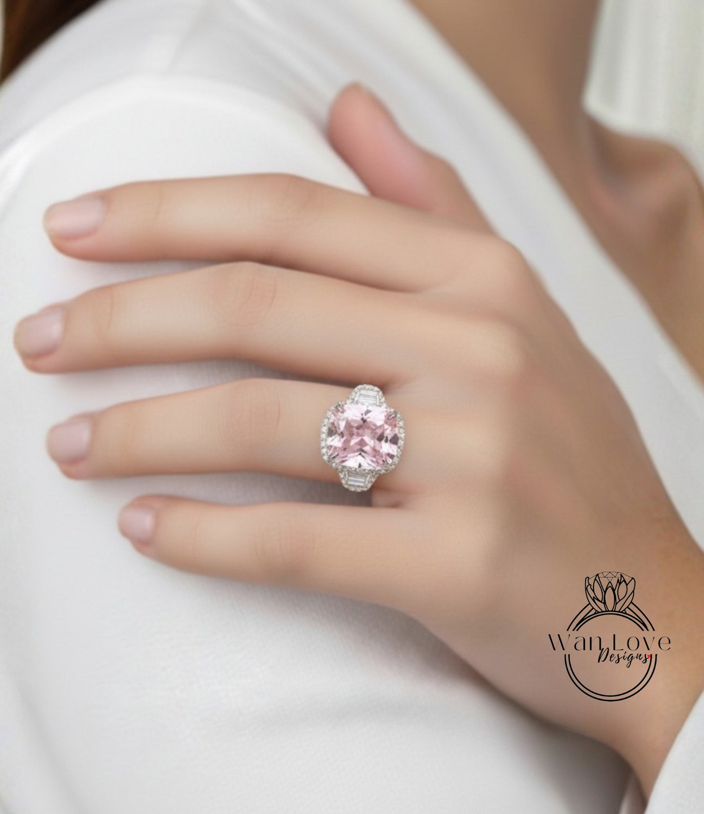 A close-up of a person's hand wearing a large, pink gemstone ring.