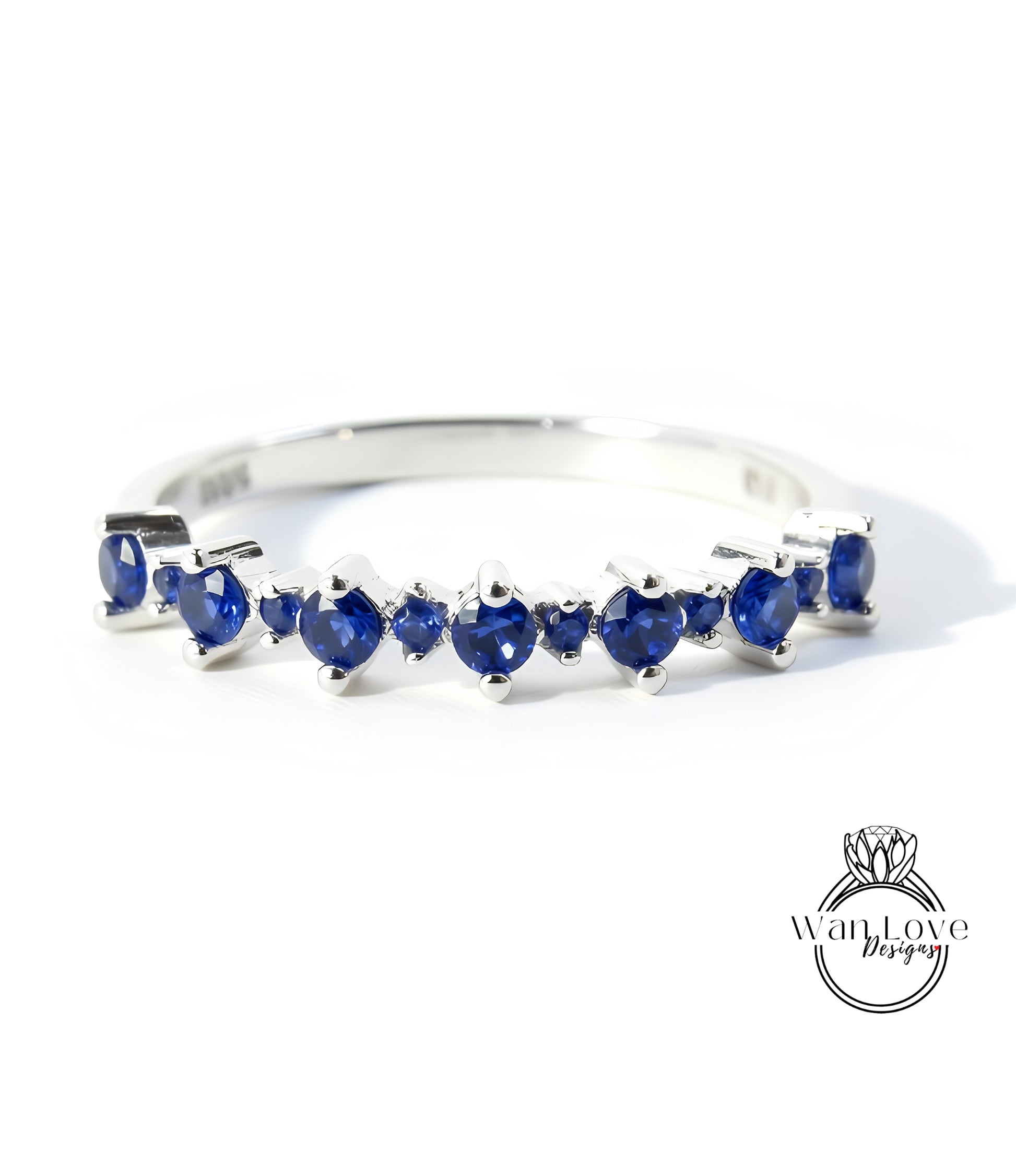 A silver ring with a row of blue sapphire stones set in it.