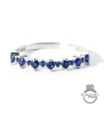 A silver ring with a row of blue sapphire stones set in it.