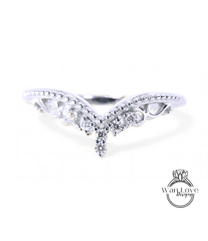 A silver ring with a decorative design featuring a central diamond and smaller diamonds surrounding it.