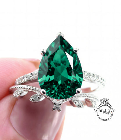 A close-up of a person's hand holding a ring with a large, green gemstone.