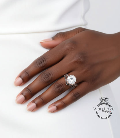 A close-up of a hand wearing a diamond engagement ring, with a white dress visible in the background.