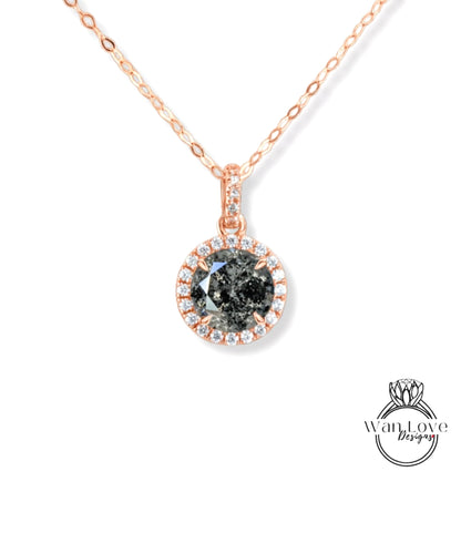 A necklace with a large, dark grey diamond pendant surrounded by smaller diamonds and set in a rose gold-colored frame.