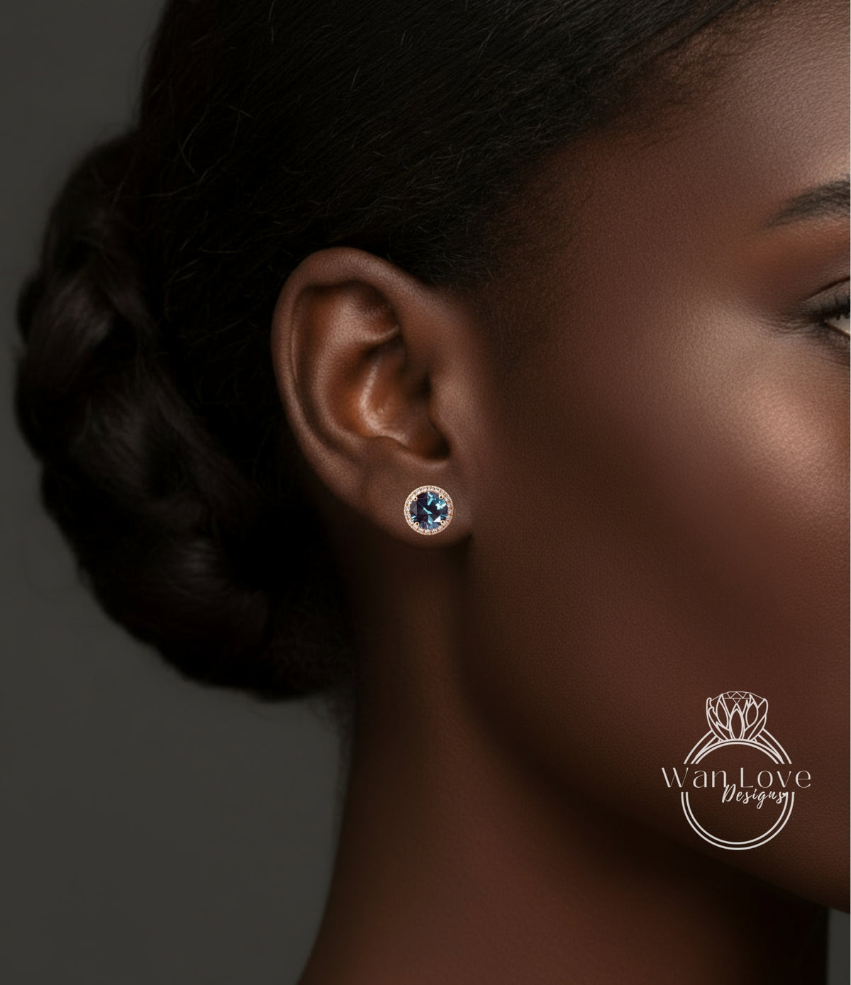A close-up of a woman's ear wearing a pair of earrings with a blue gemstone.