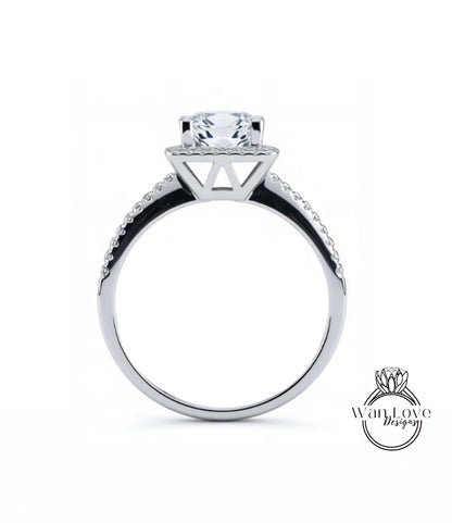 A silver engagement ring with a large central diamond and a halo of smaller diamonds around the top.