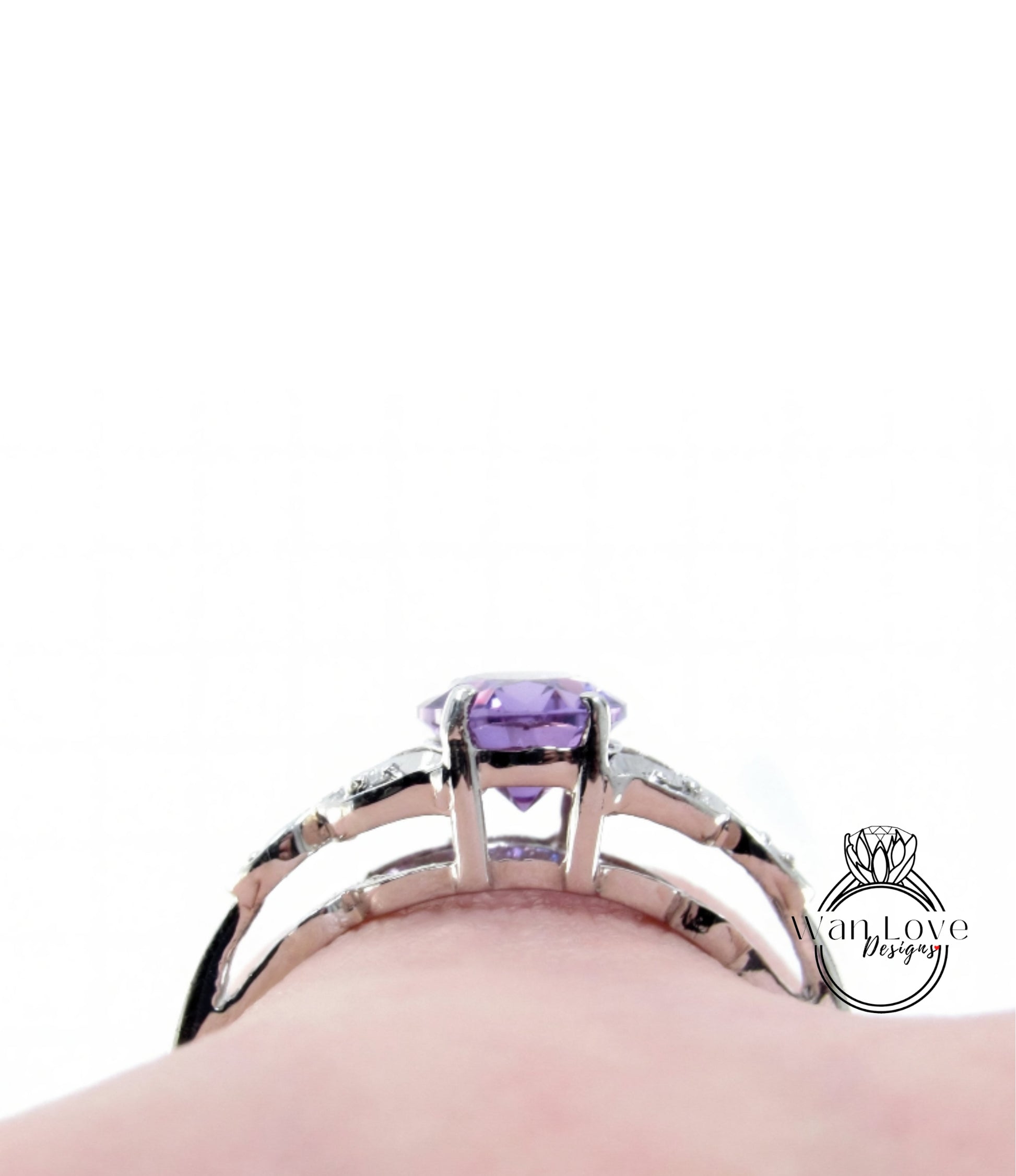 A close-up view of a silver ring with a purple gemstone, likely an amethyst, set in a halo of smaller diamonds.