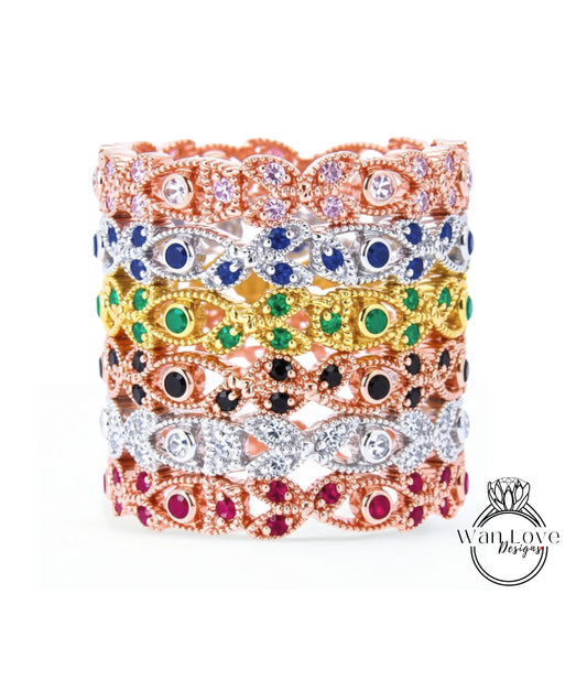 A stack of colorful, ornate rings with various gemstones and designs.