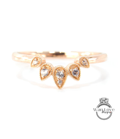 A gold ring with a decorative band featuring a cluster of small, clear gemstones.