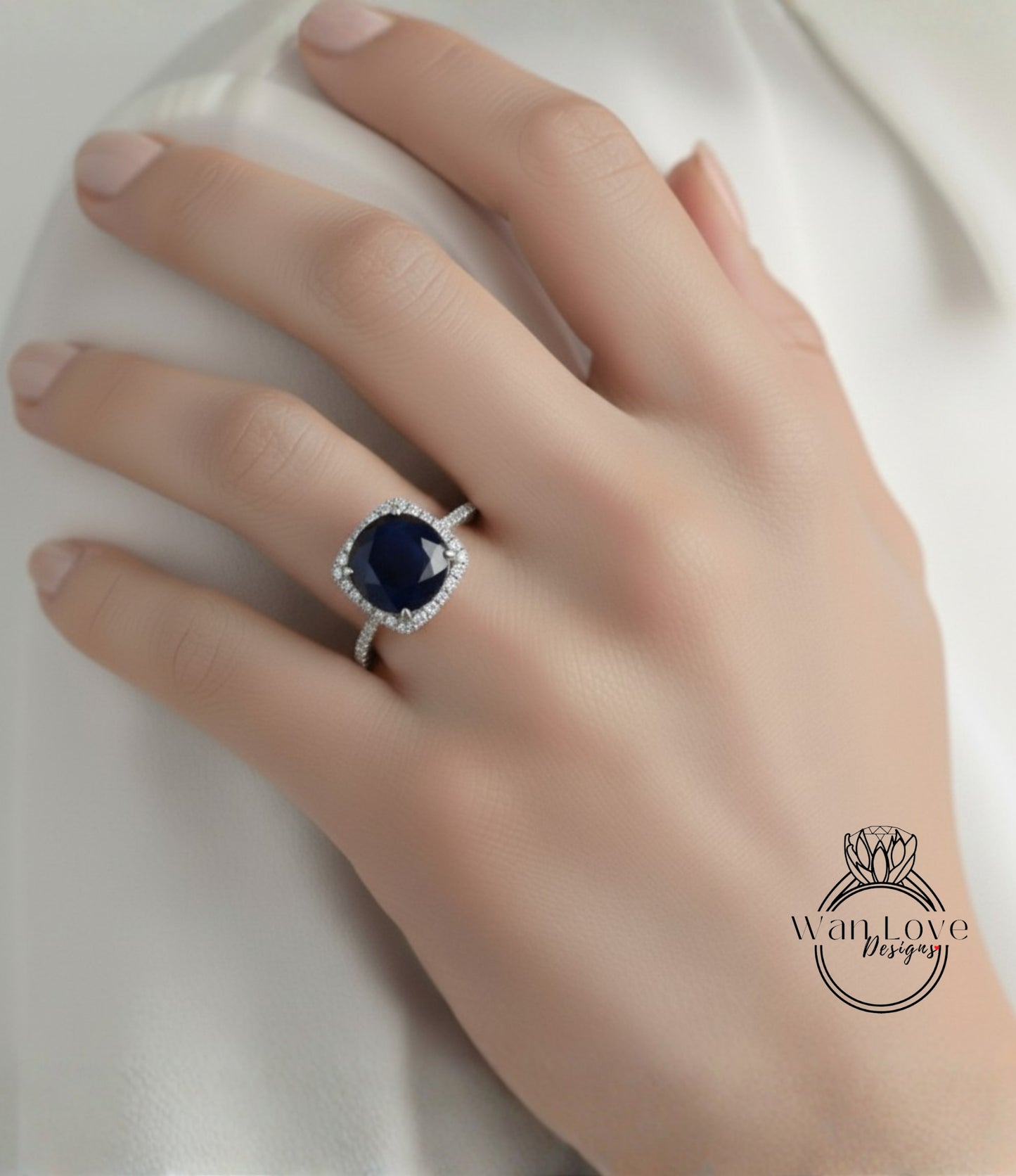 A close-up of a hand wearing a diamond ring with a large blue gemstone.