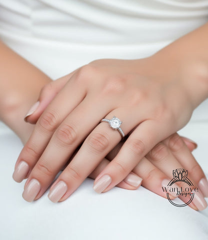 A close-up image of a person's hands wearing a diamond engagement ring.