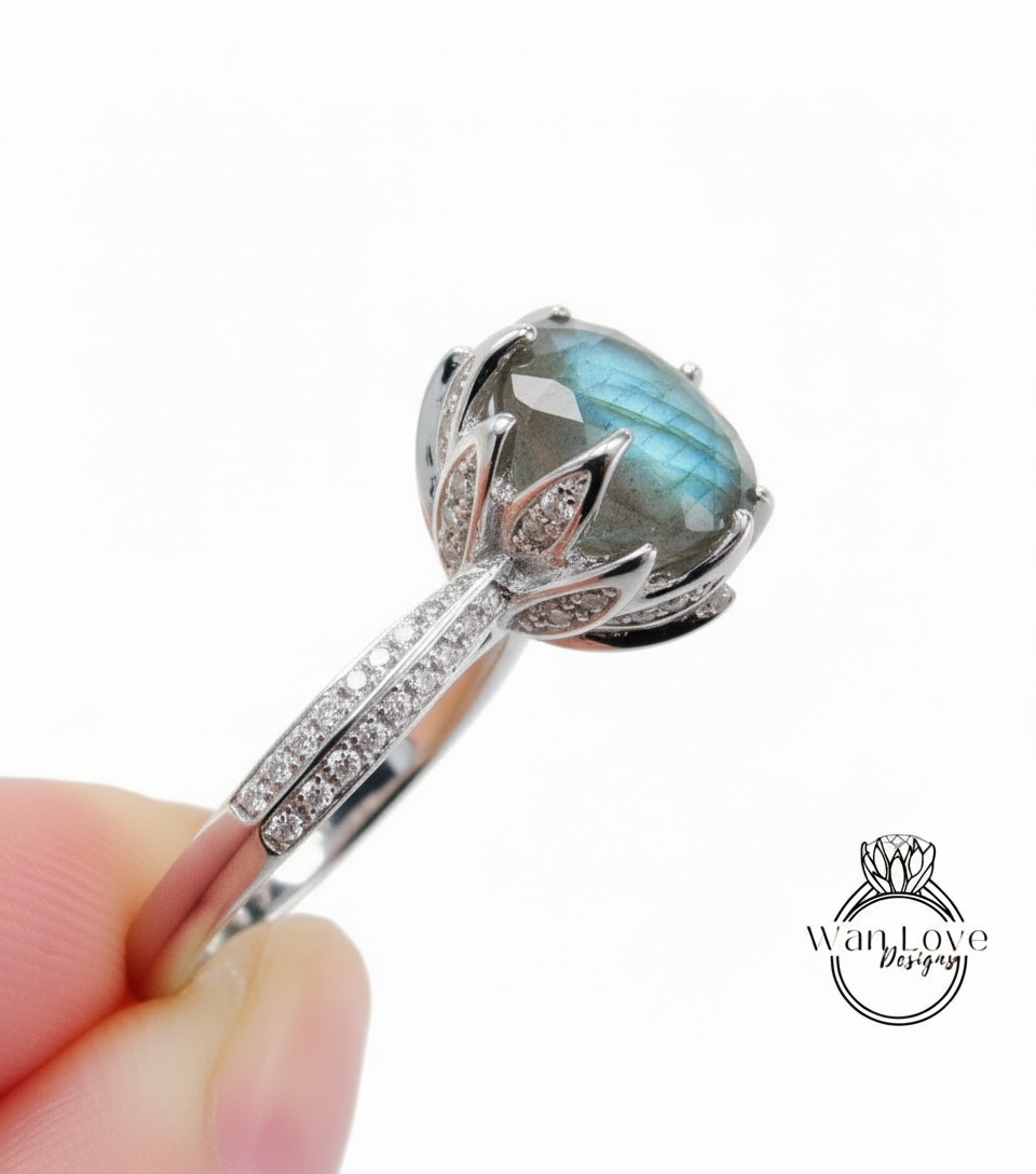 A close-up image of a silver ring with a large blue gemstone, possibly a diamond, set in a decorative floral design.