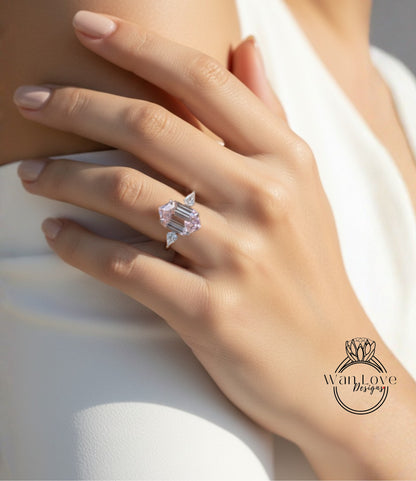 A close-up of a person's hand wearing a large, pink diamond ring.