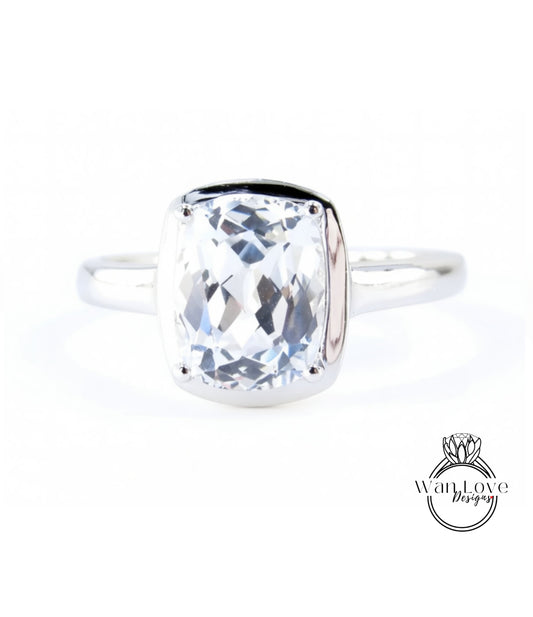 A silver ring with a large, clear gemstone set in the center.