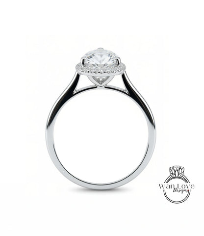 A close-up view of a silver engagement ring with a large, round diamond at the center, surrounded by a halo of smaller diamonds.