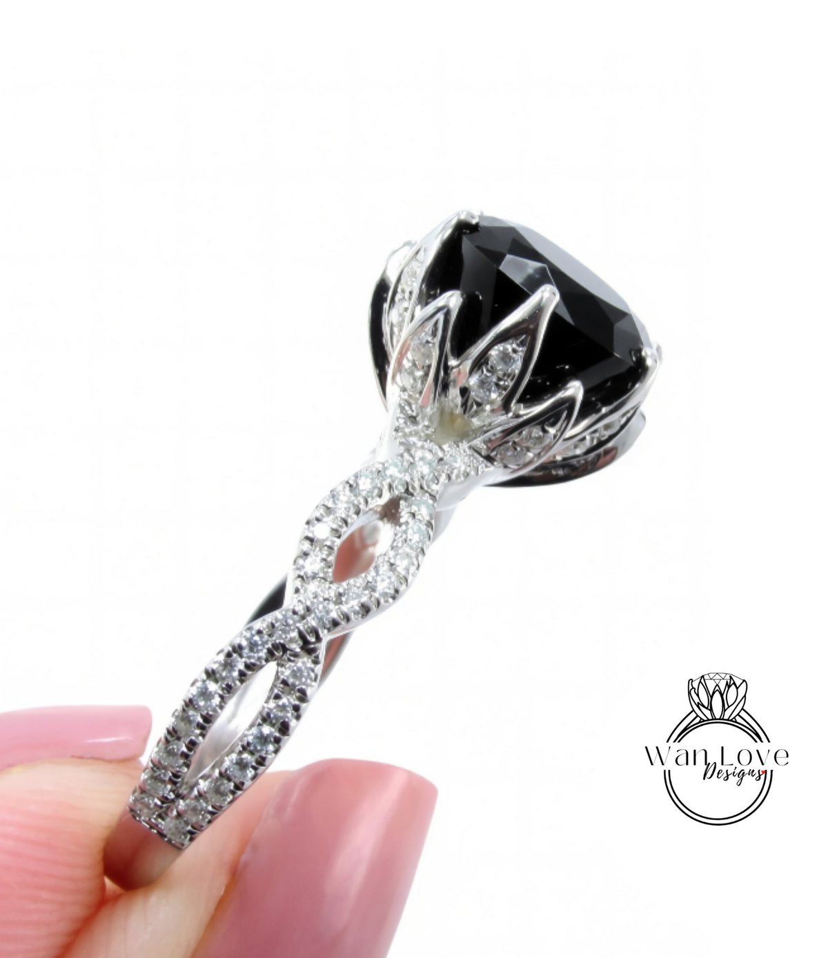 A close-up of a diamond engagement ring with a large black gemstone and intricate silver detailing.