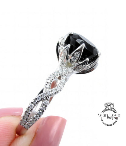 A close-up of a diamond engagement ring with a large black gemstone and intricate silver detailing.