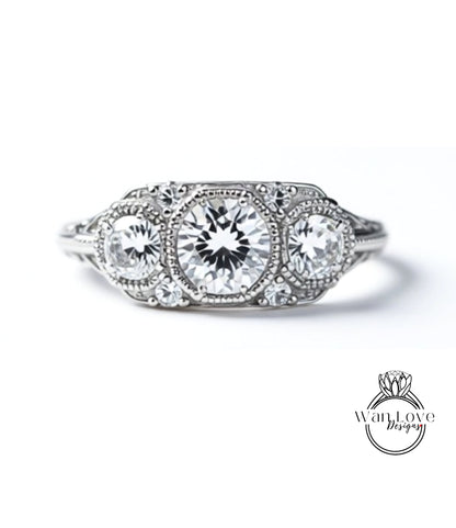 A close-up view of a diamond engagement ring with three large, clear gemstones set in a decorative metal band.