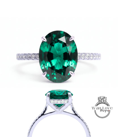 A large oval-shaped green gemstone set in a silver ring with a small diamond accent.