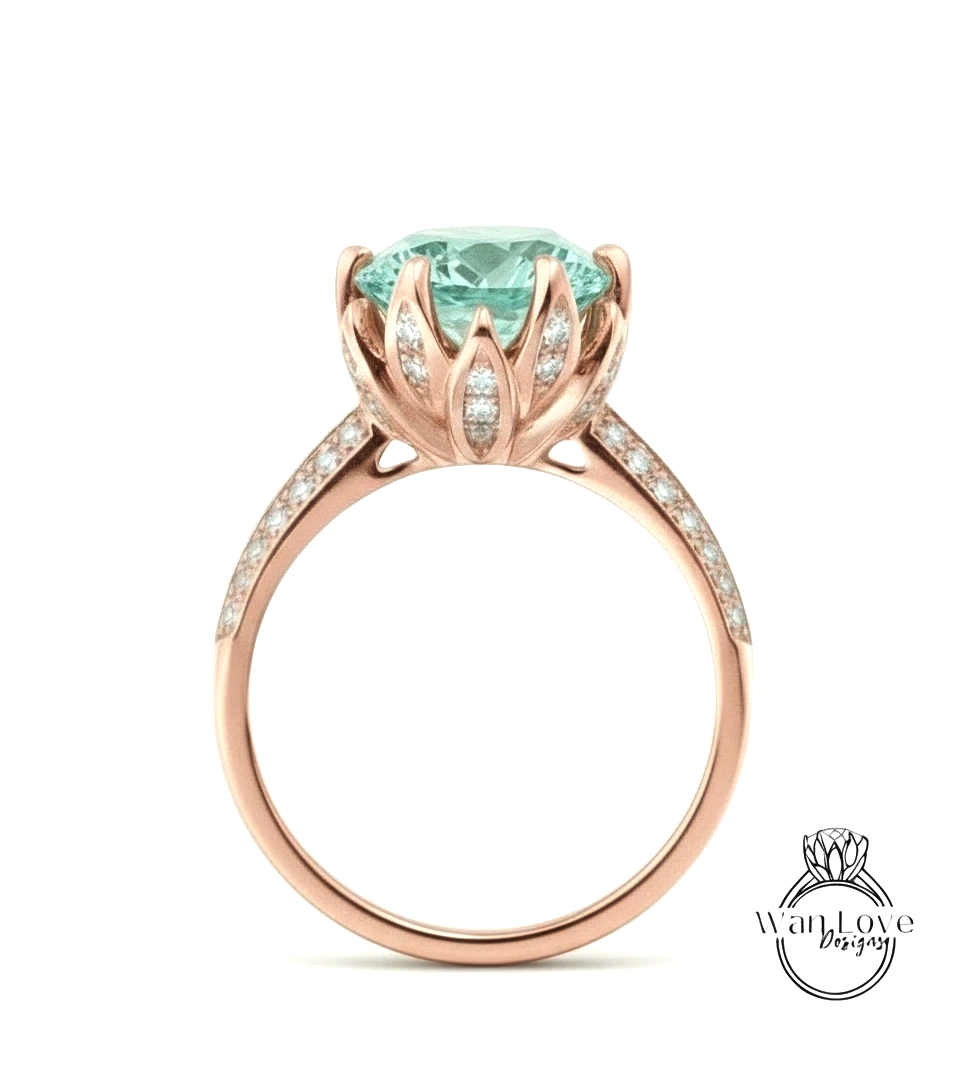 A rose gold ring with a large, light blue gemstone set in the center, surrounded by smaller diamonds.