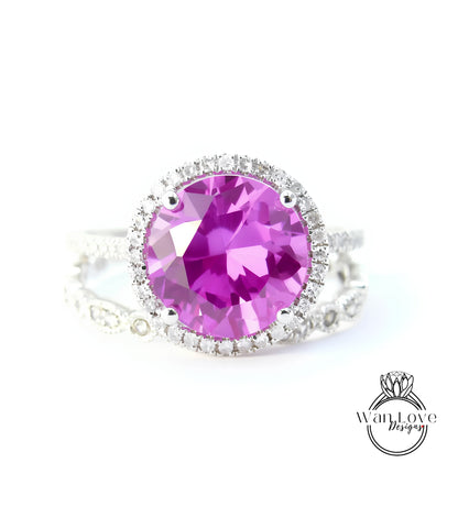 A close-up image of a ring with a large, bright pink gemstone set in a halo of smaller diamonds.