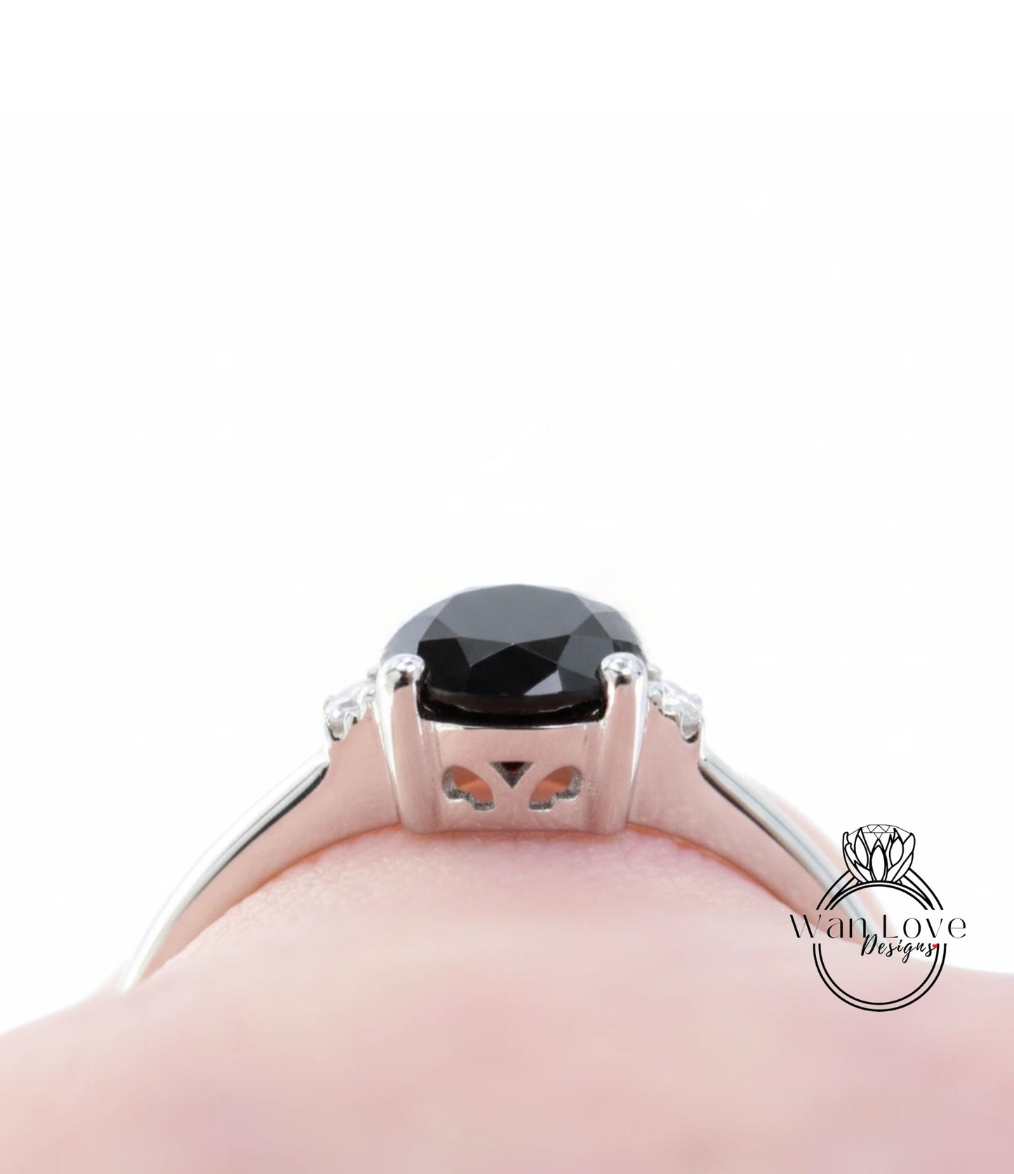 A close-up view of a silver ring with a large black gemstone, likely a diamond, set in the center.