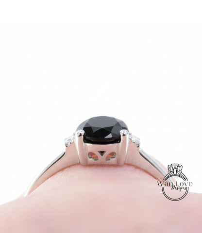 A close-up view of a silver ring with a large black gemstone, likely a diamond, set in the center.