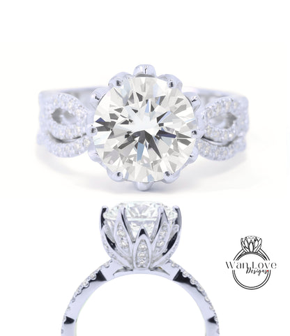 A stunning diamond engagement ring with a large round brilliant cut diamond set in a silver band adorned with smaller diamonds. The ring is designed with a large central diamond surrounded by smaller diamonds on either side, creating a beautiful floral-inspired design.
