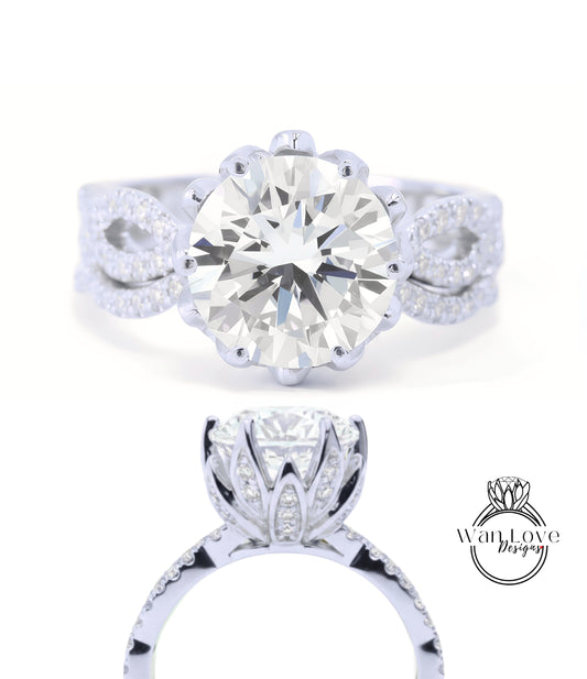 A stunning diamond engagement ring with a large round brilliant cut diamond set in a silver band adorned with smaller diamonds. The ring is designed with a large central diamond surrounded by smaller diamonds on either side, creating a beautiful floral-inspired design.