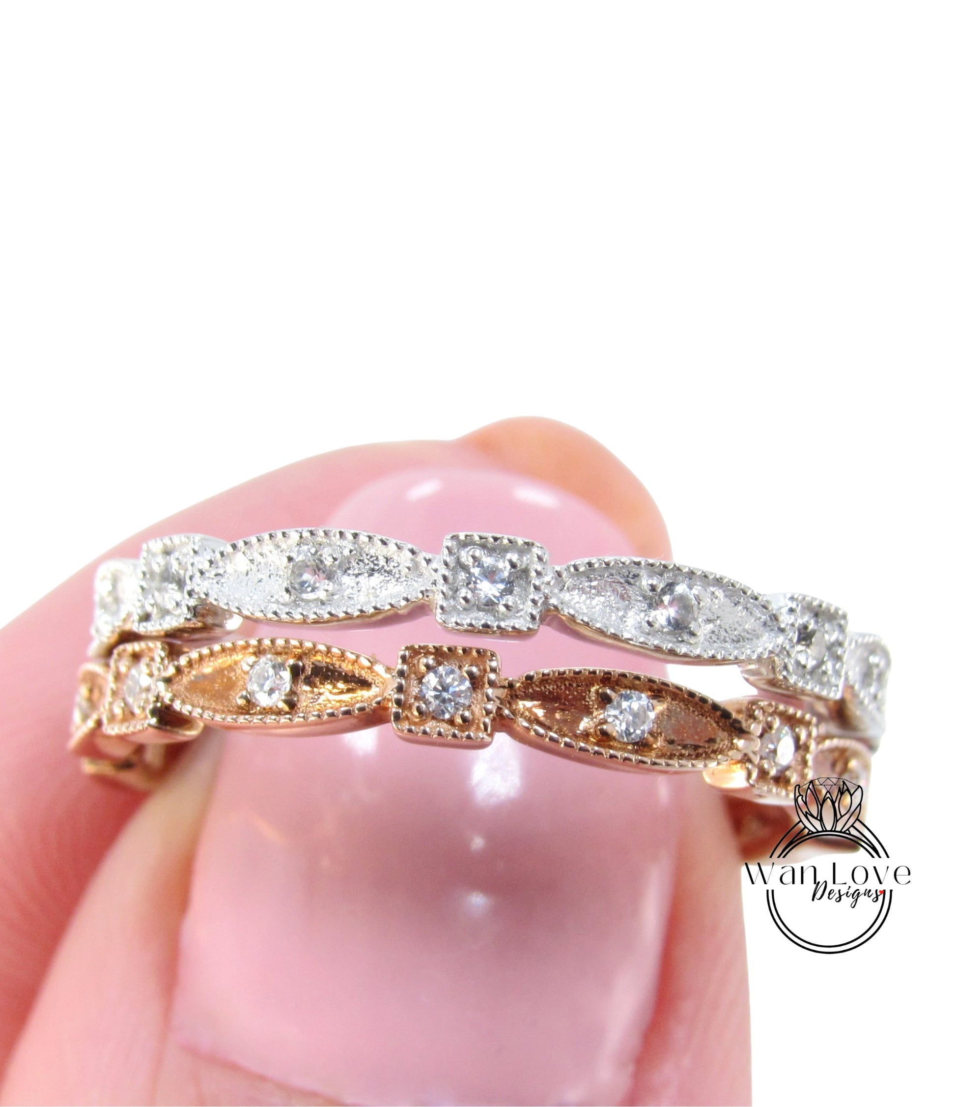 A close-up image of a person's hand holding a ring with a row of diamond-encrusted stones.