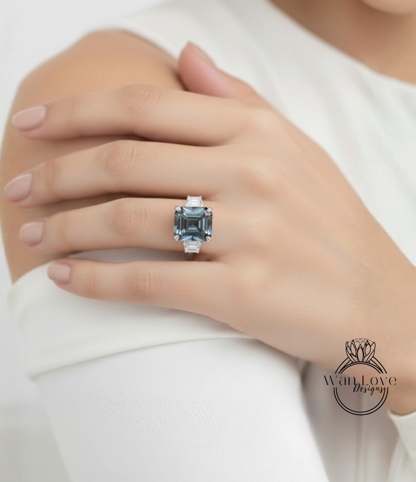A close-up of a person's hand wearing a large, blue gemstone ring on the ring finger.