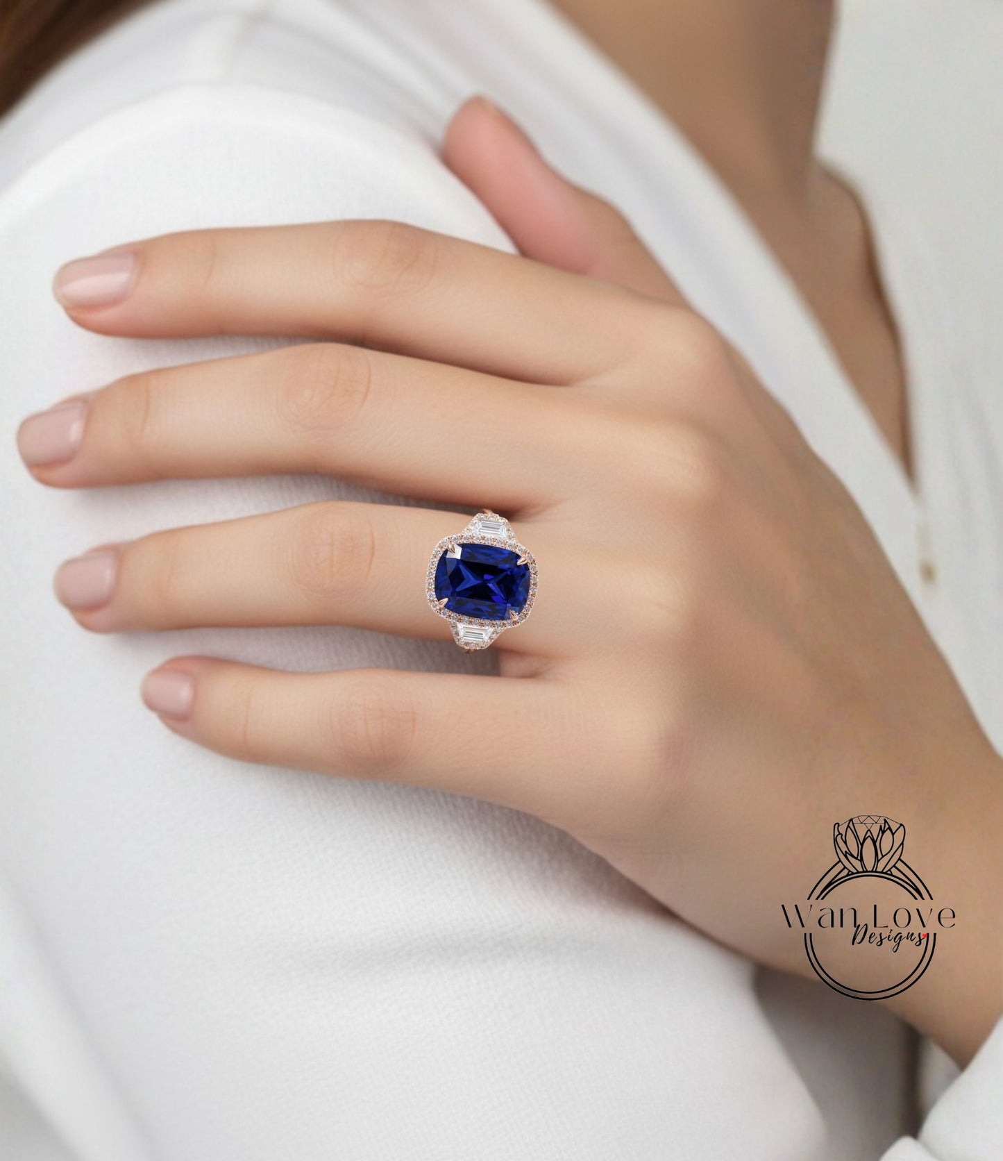 A close-up of a person's hand wearing a large, blue gemstone ring on the ring finger.
