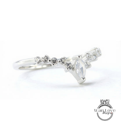 A silver ring with a large central stone surrounded by smaller stones, creating a decorative design.