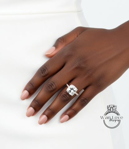 A close-up of a person's hand wearing a large diamond engagement ring.