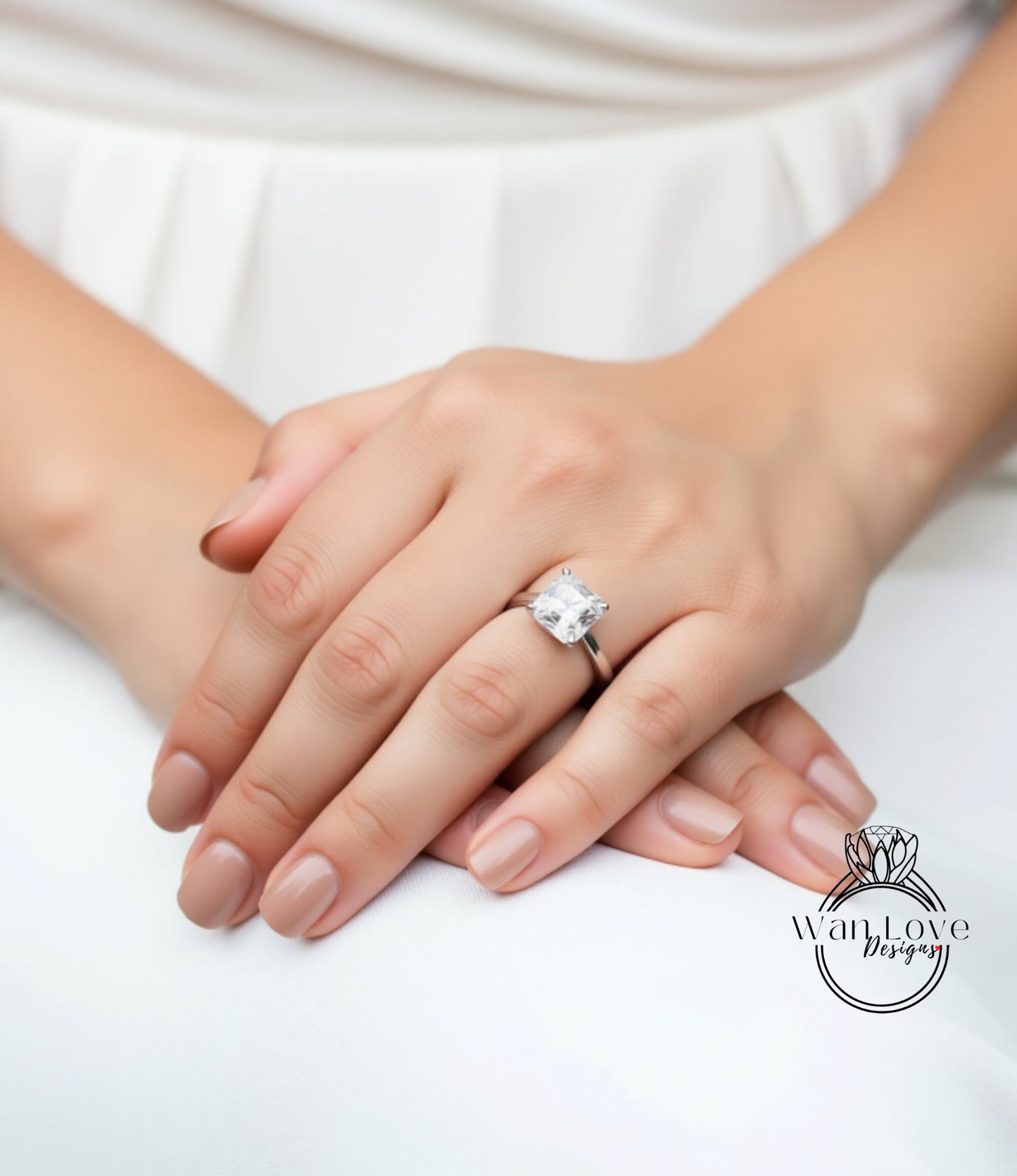 A close-up image of a person's hands wearing a large diamond engagement ring.