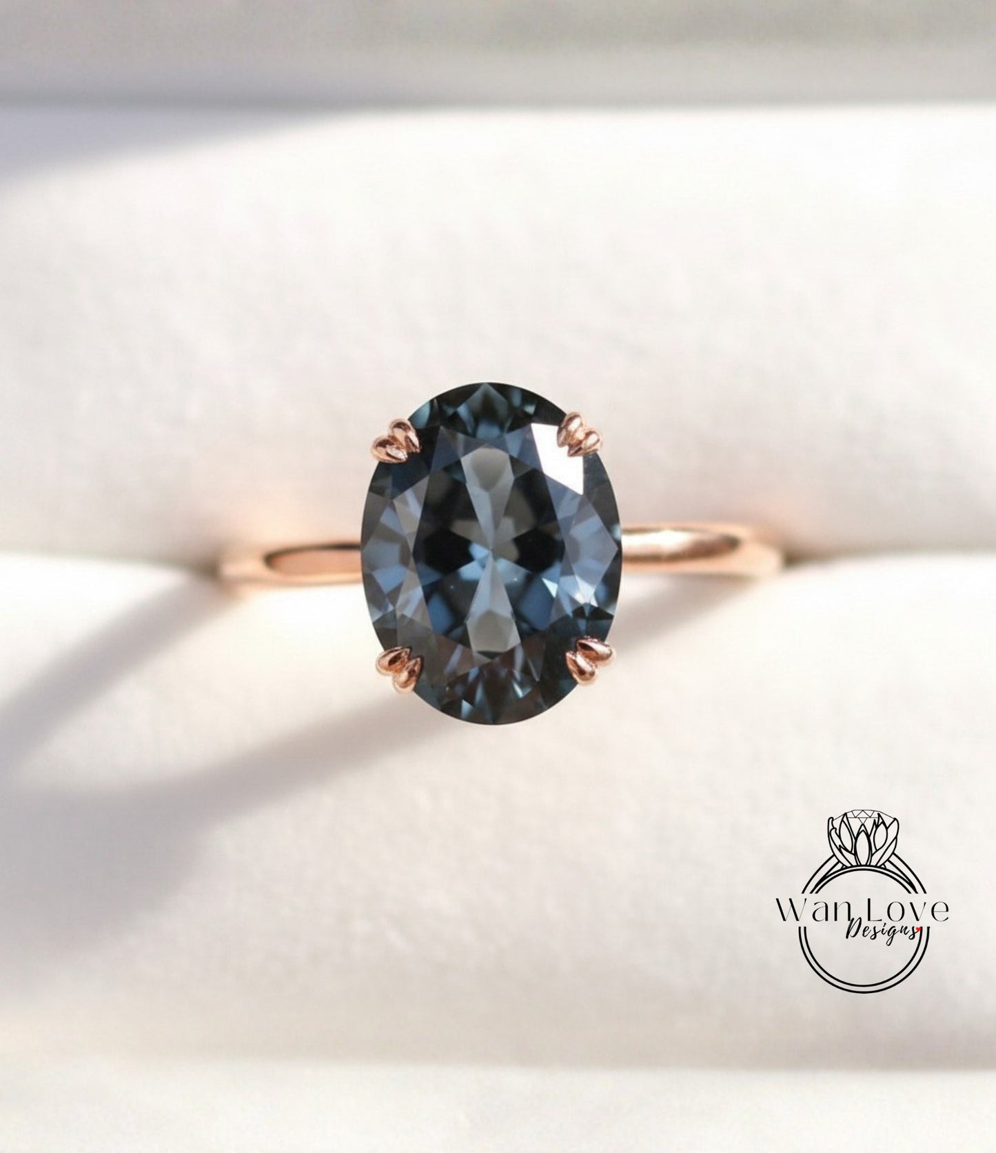 A close-up image of a gold ring with a large oval-shaped blue gemstone, placed on a white background.