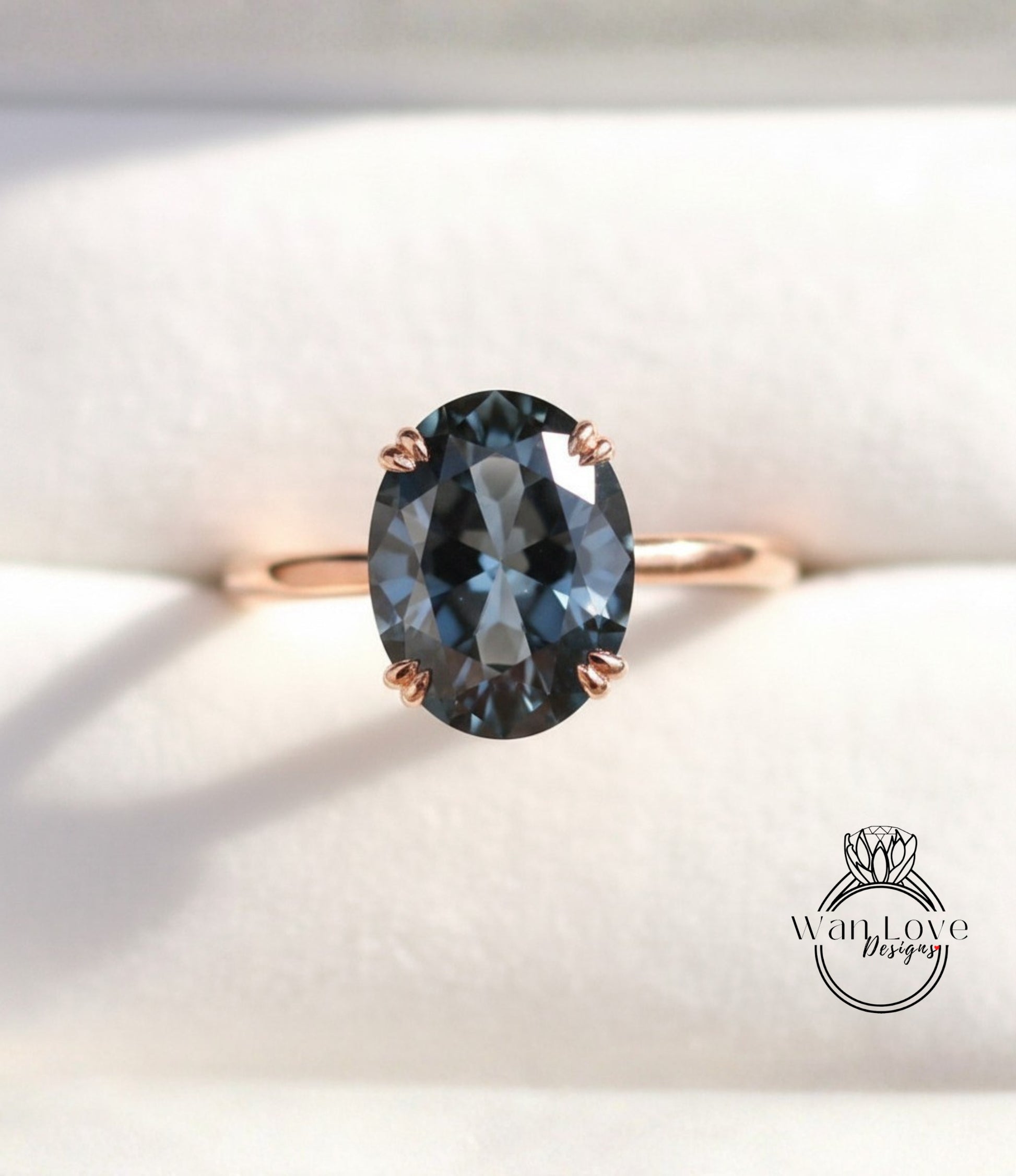 A close-up image of a gold ring with a large oval-shaped blue gemstone, placed on a white background.