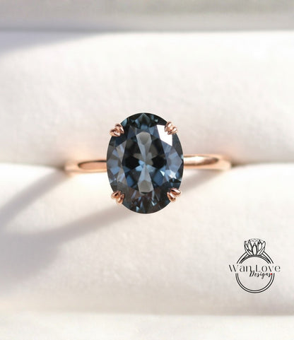 A close-up image of a gold ring with a large oval-shaped blue gemstone, placed on a white background.