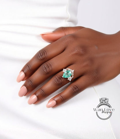 A close-up of a hand wearing a ring with a large, green gemstone.