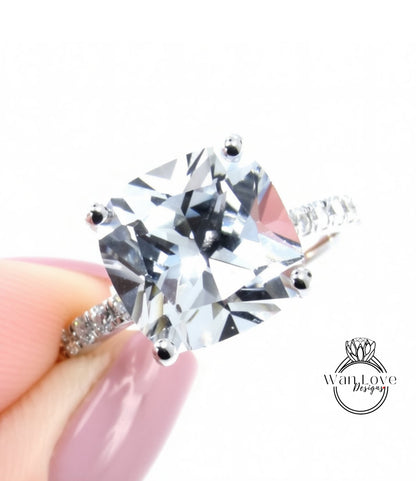 A close-up of a diamond engagement ring being held in someone's hand, showcasing the large, clear gemstone.