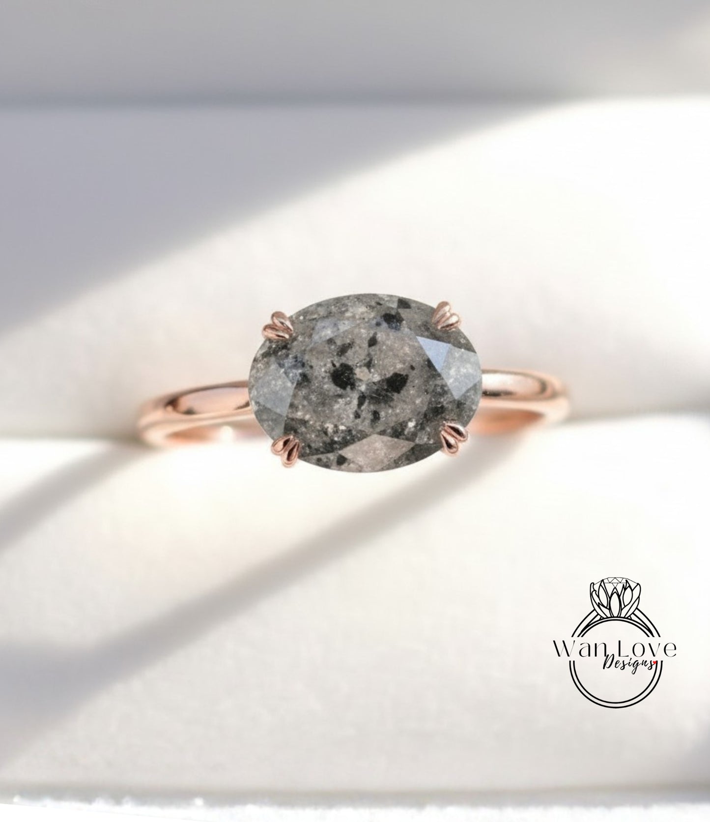 A rose gold ring with a large oval-shaped diamond as the centerpiece.