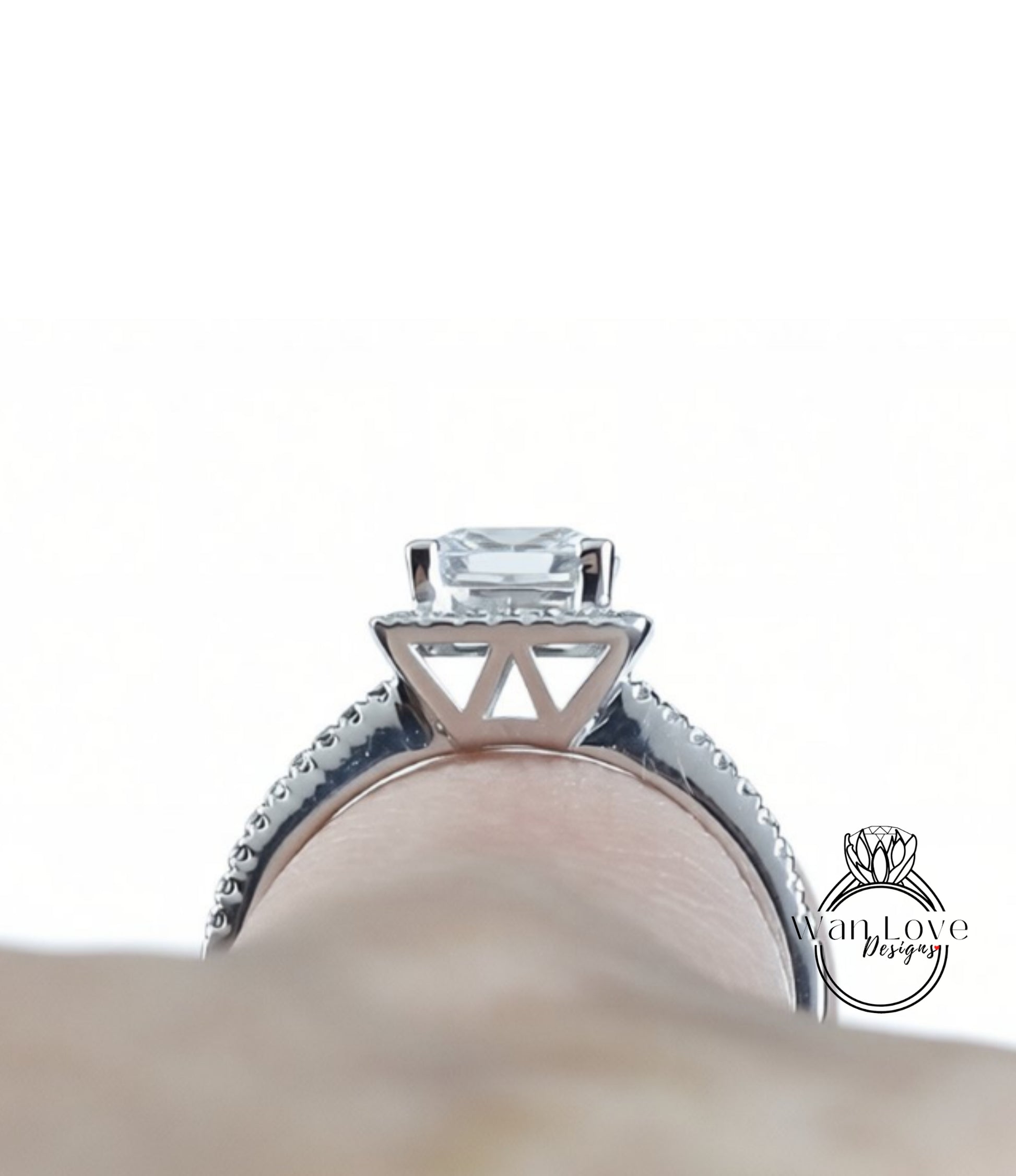 A close-up view of a diamond engagement ring on a person's finger, showcasing the intricate design and sparkling gemstone.