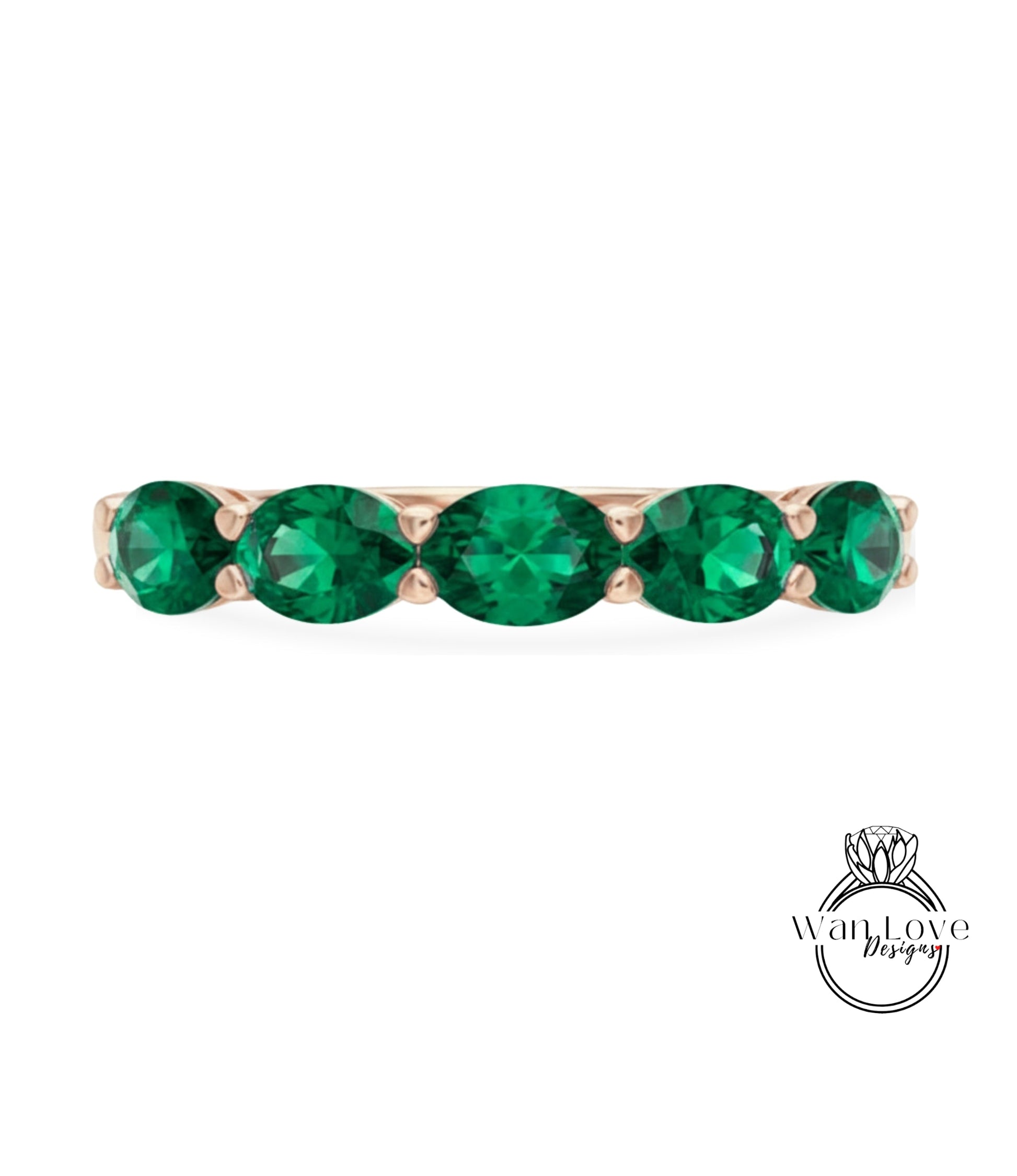 A gold ring with a row of green gemstones, likely diamonds, set in the center.
