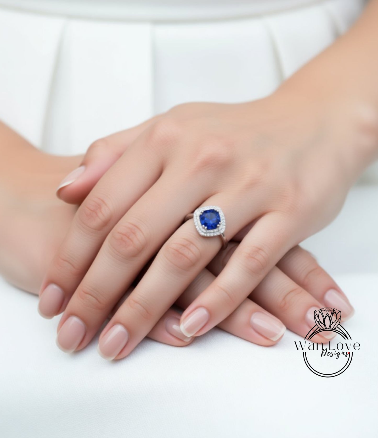 A close-up image of a person's hands wearing a ring with a blue gemstone.